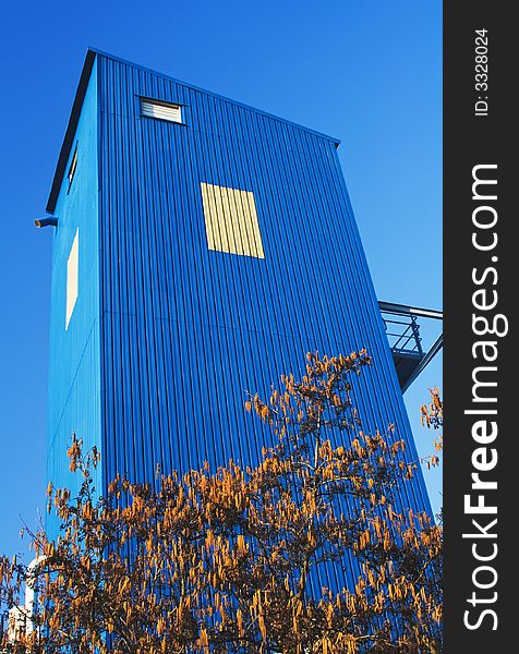 Bright blue industrial building against a clear blue sky