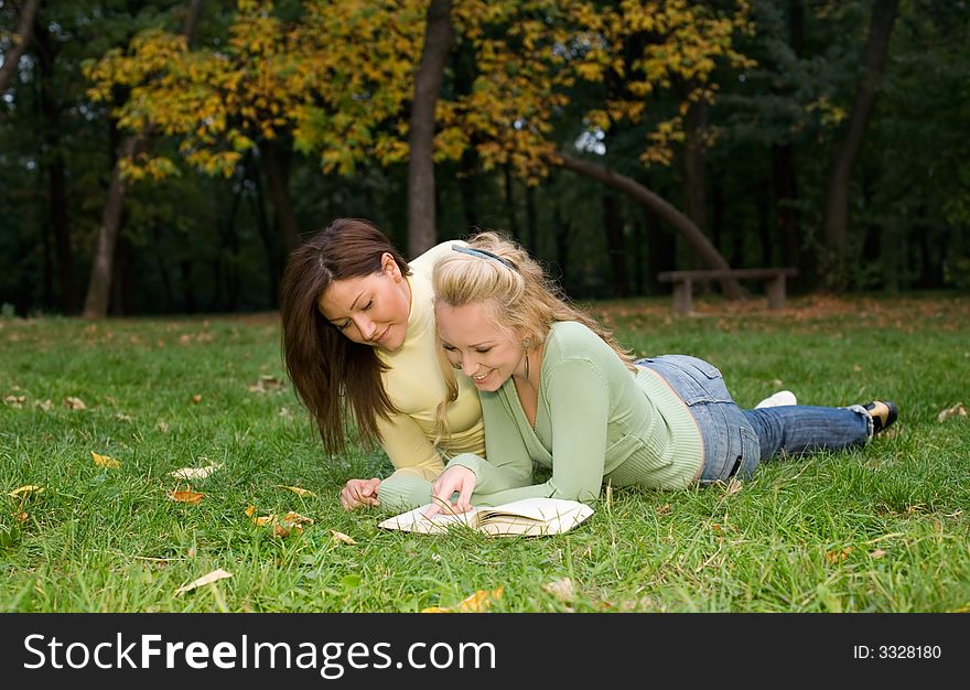 Two students reading at the park. Two students reading at the park
