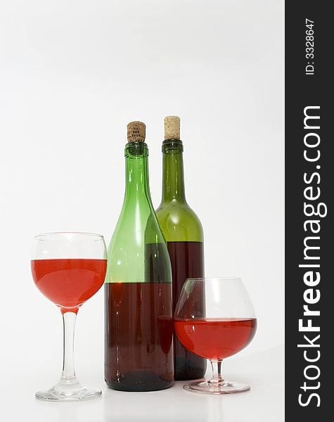 Red wine bottles and glasses isolated over white