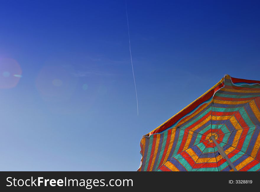 Colorful sunshade against a clear blue sky