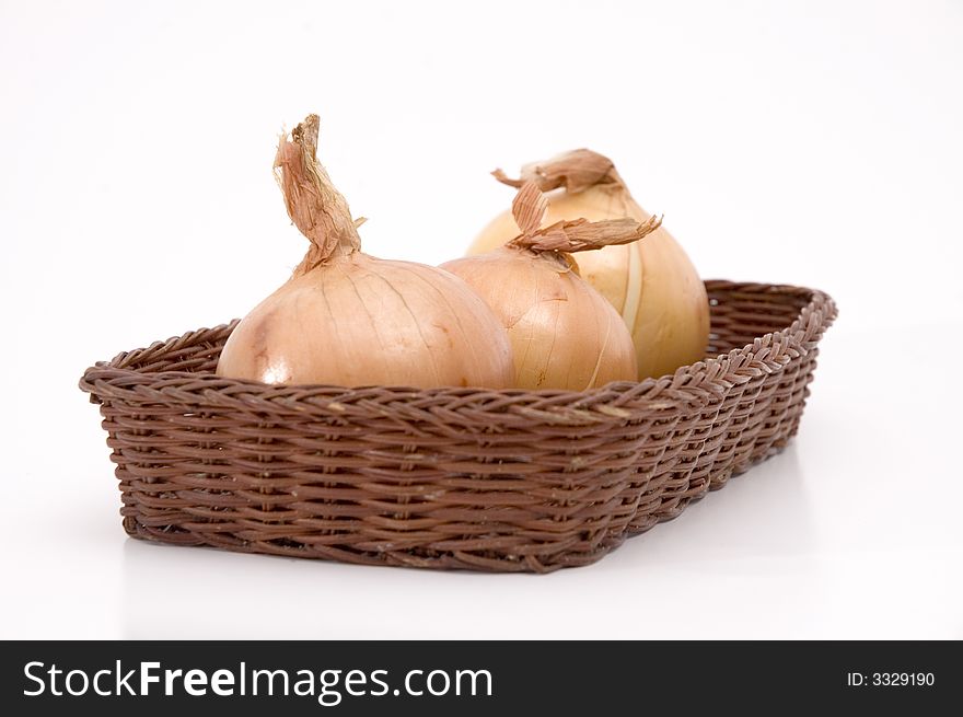Group of onions on a basket isolated over white