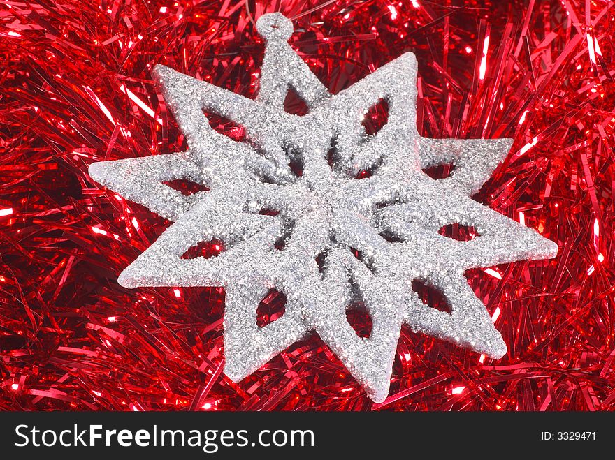 Silver glitter snowflake on red tinsel