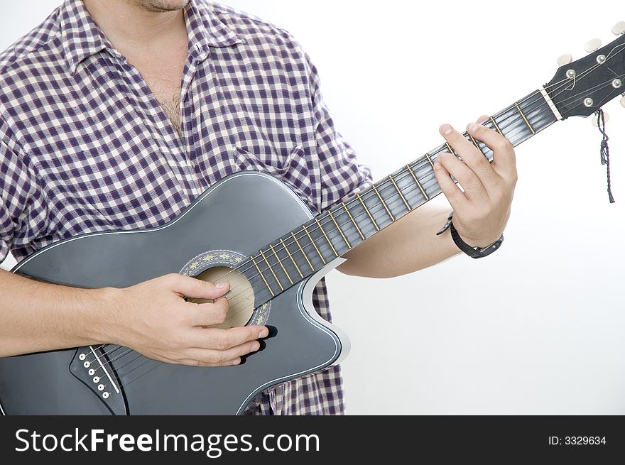 A young male playing acoustic guitar - isolated. A young male playing acoustic guitar - isolated