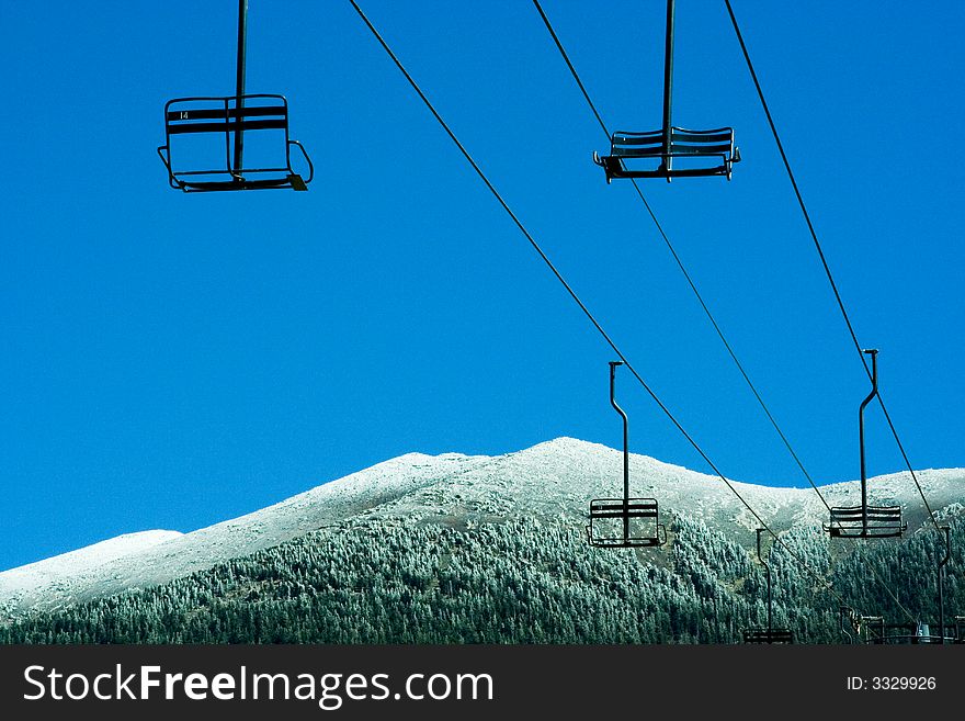 Ski lifts at ski resort with mountain snow.