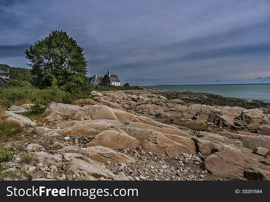 An image of the Old small Church beside the Saint-Lawrence river seen from a quay in Port au Persil Quebec. An image of the Old small Church beside the Saint-Lawrence river seen from a quay in Port au Persil Quebec