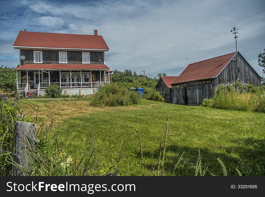 An image of small farm beside the Saint-Lawrence river seen from a quay in Port au Persil Quebec
