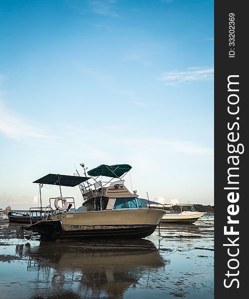 Motor boat with low tide under blue sky