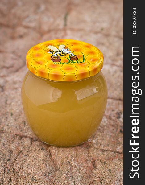 Nice gift jar of honey on stone background