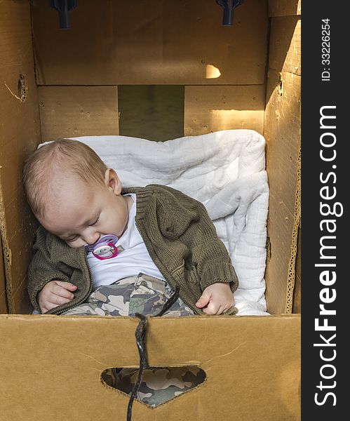 Small Baby sleeping in cardboard box. Small Baby sleeping in cardboard box.