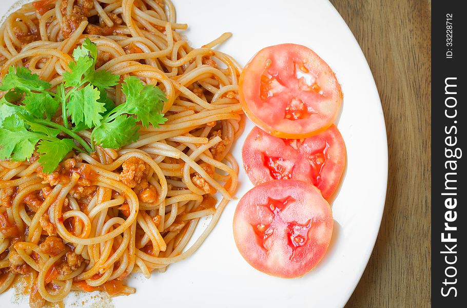 Spaghetti with pork tomato sauce on white plate