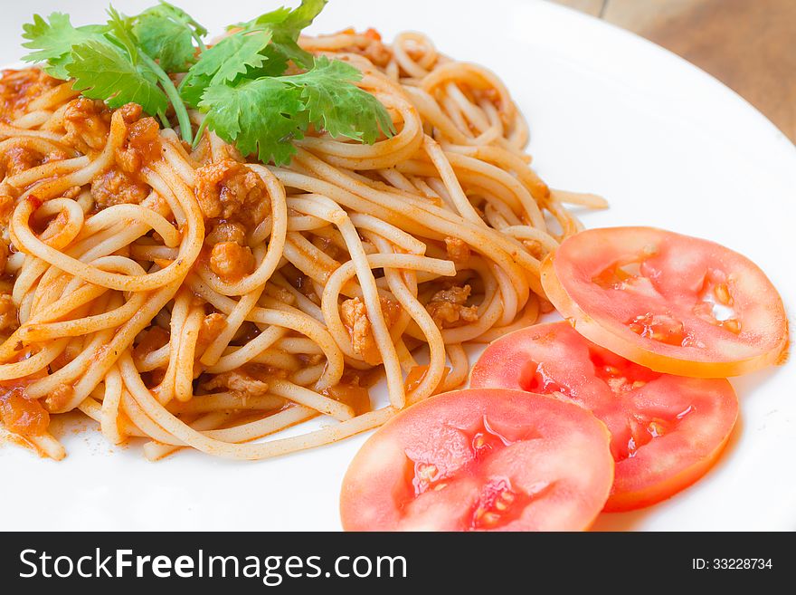 Spaghetti with pork tomato sauce on white plate