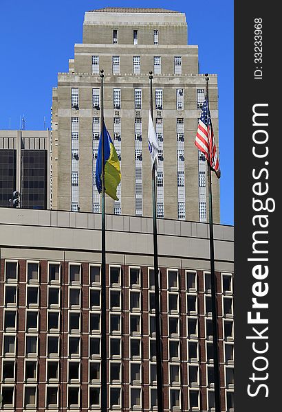 Three colorful flags waving in morning breeze,standing tall in front of business buildings. Three colorful flags waving in morning breeze,standing tall in front of business buildings.