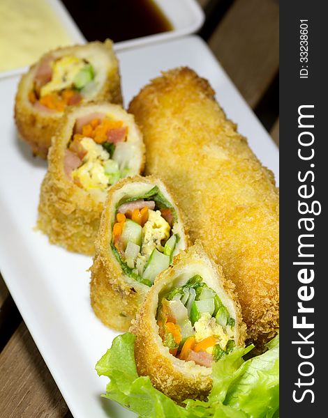 Deep Fried roll salad mix meal on white plate
