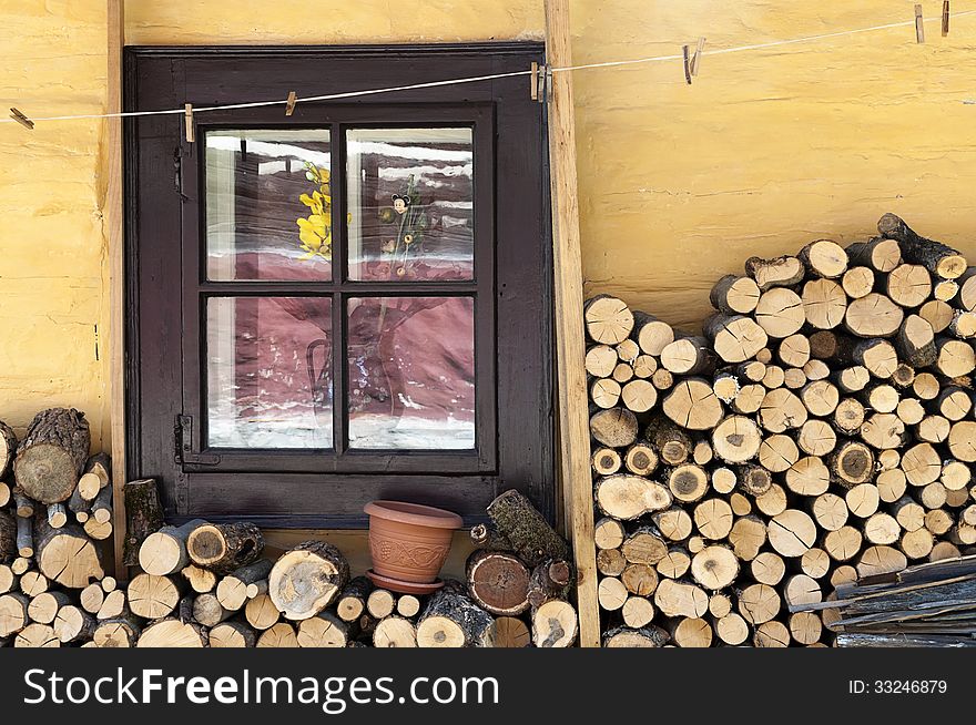 Wooden window of a traditional country cottage house with firewood logs. Wooden window of a traditional country cottage house with firewood logs.