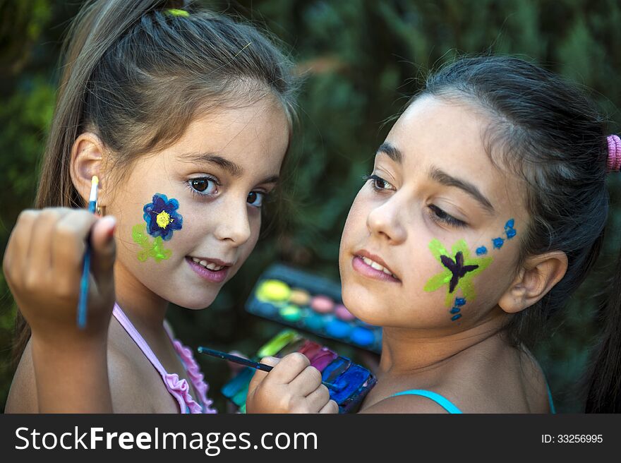 Playful children - girls painted face. Playful children - girls painted face