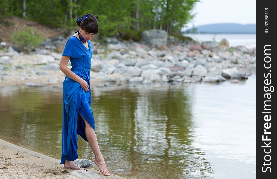 Girl in evening dress on a blue lake