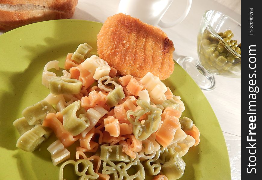 Colored noodles and chicken Kiev on a bamboo plate