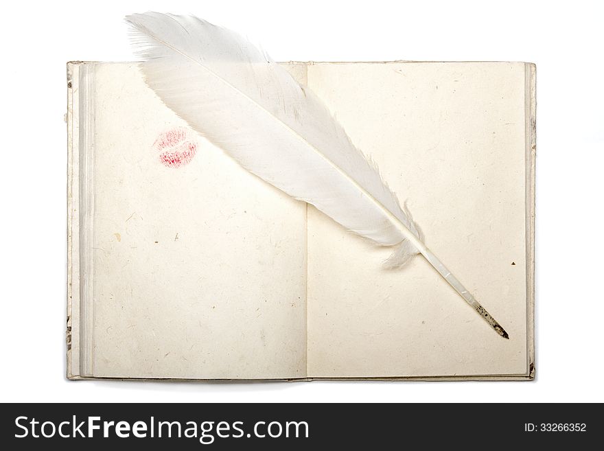 Open diary with japan paper lipstick kiss and feather pen isolated on white.