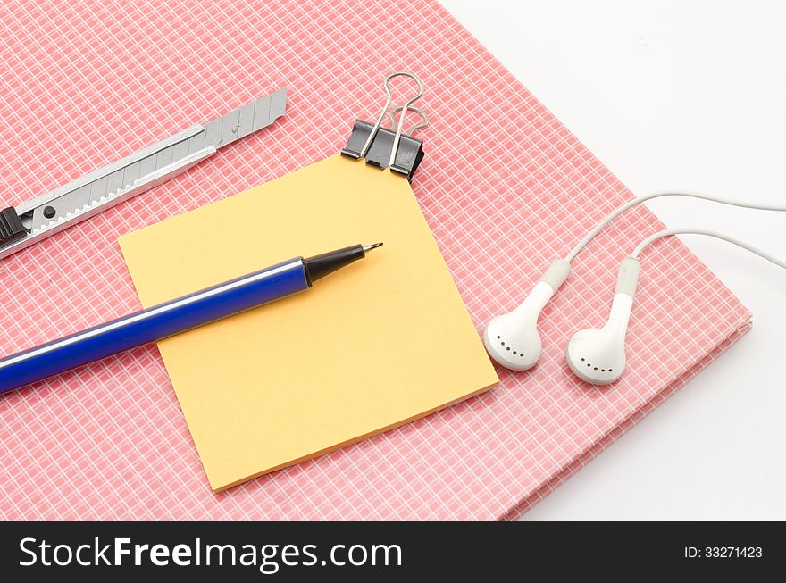 Red notebook with post it and bulldog clip blue pen cutter ear p