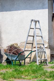 Metal Ladder And A Wheelbarrow By The Old Wall Stock Photography Metal Ladder And A Wheelbarrow By The Old Wall Stock Photography