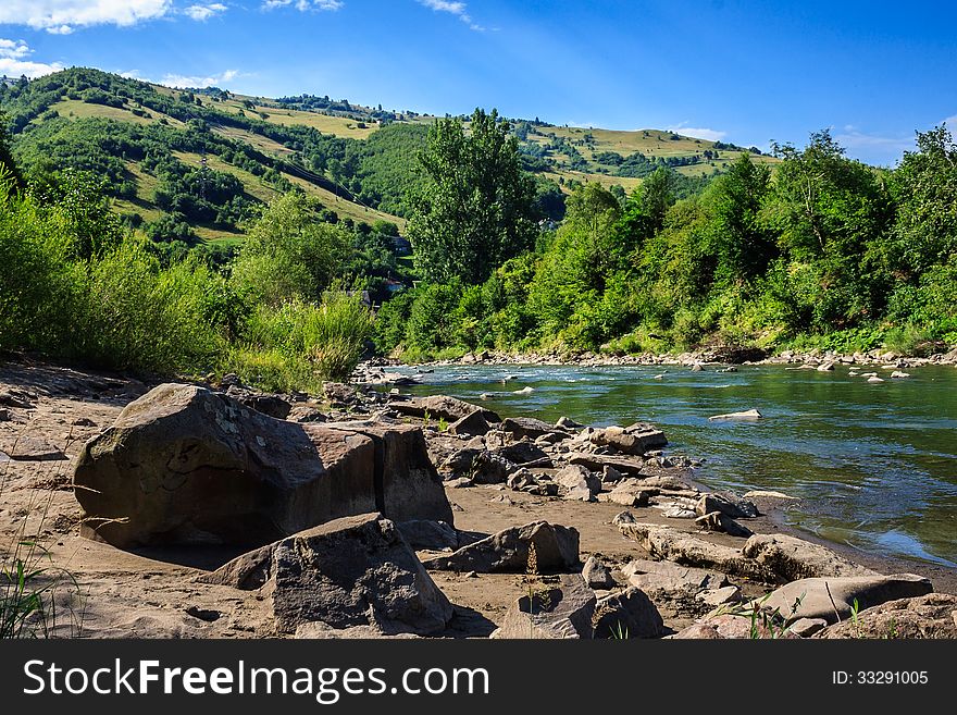 Stone river beach near the mountain village