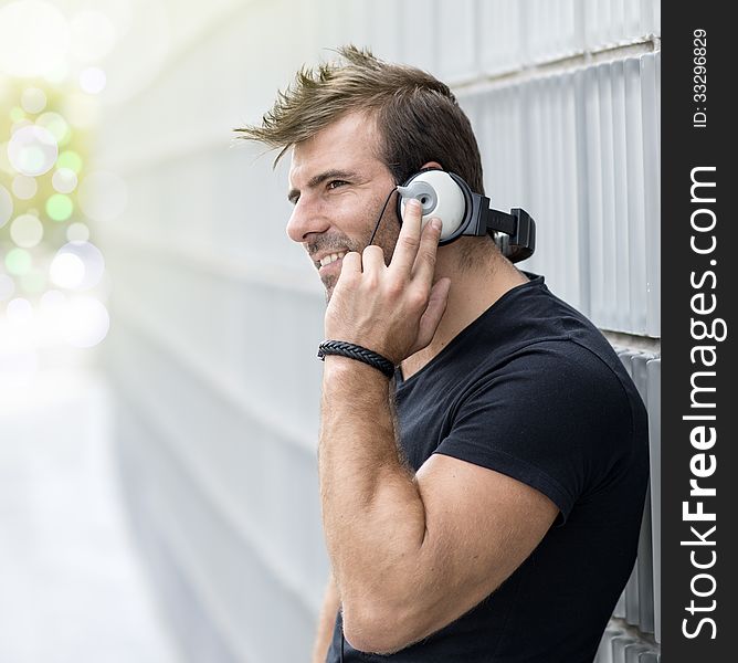 Portrait Of Man Listening To Music Wiyh Headphones Against In Ab