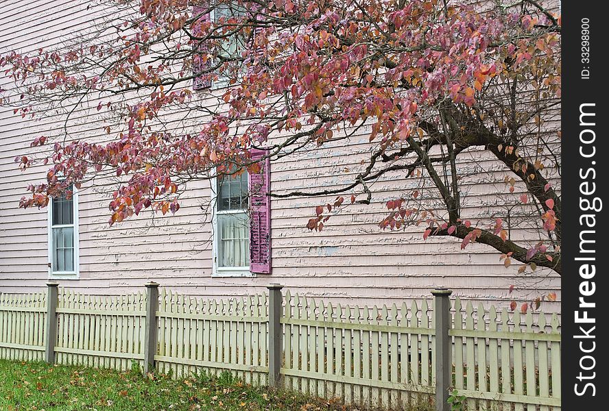 An old colorful home with Autumn tree and pickett fence. An old colorful home with Autumn tree and pickett fence.