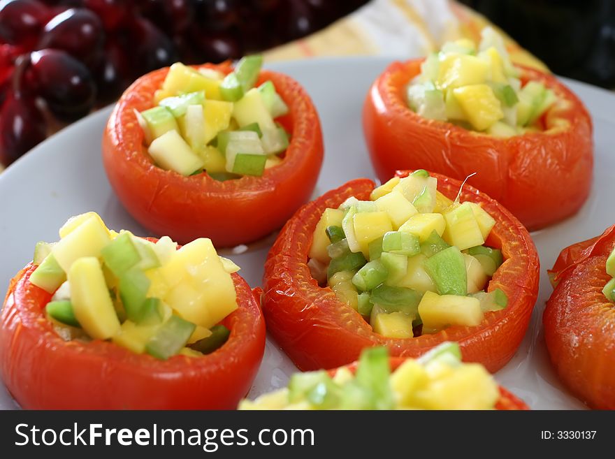 Large carved baked tomatoes with miniature mango and star fruit filling