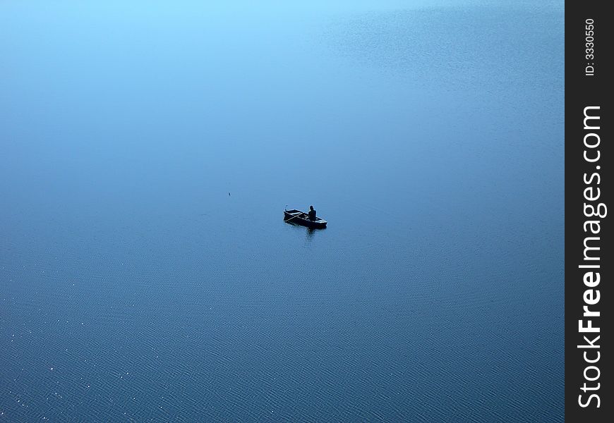 Lonely fishermen surrounded by endless water. Lonely fishermen surrounded by endless water