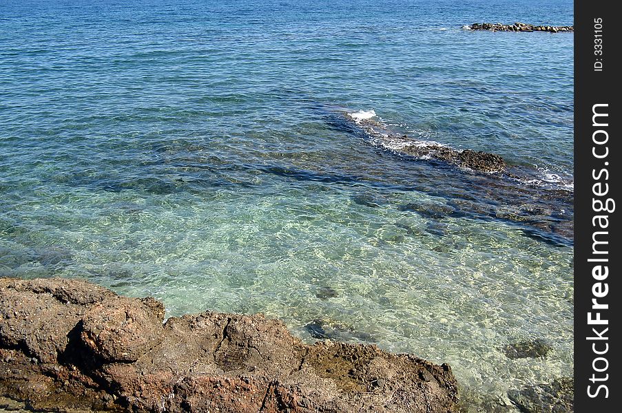 A rocky seashore with water reflections under the sunlight. A rocky seashore with water reflections under the sunlight