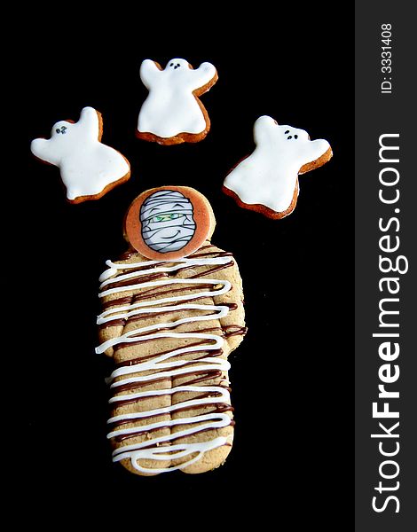 Three delicious gingerbread ghosts fly around a yummy gingerbread man. Three delicious gingerbread ghosts fly around a yummy gingerbread man