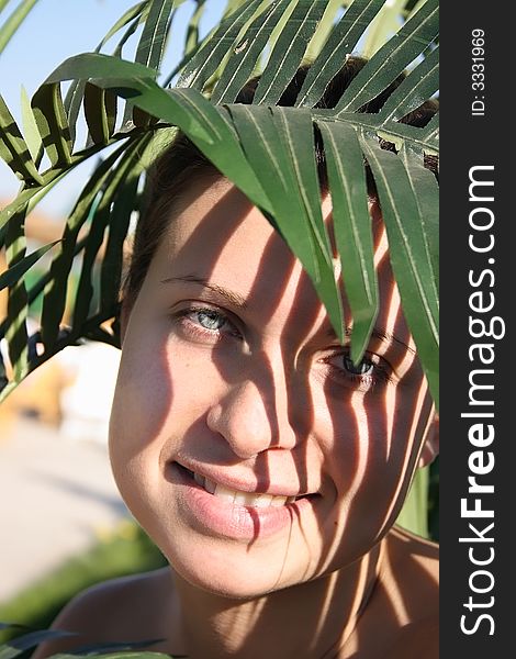 Beautiful woman in bikini with leafy shade