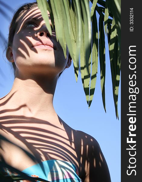 Beautiful woman in bikini with leafy shade