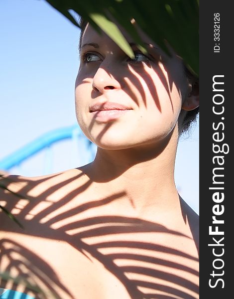 Beautiful woman in bikini with leafy shade