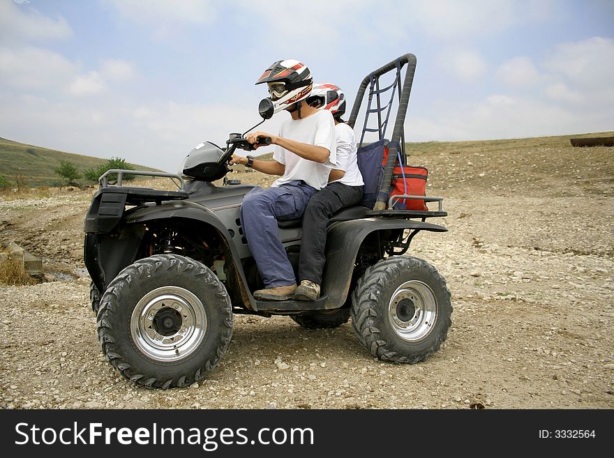 Men riding on a quad in desert