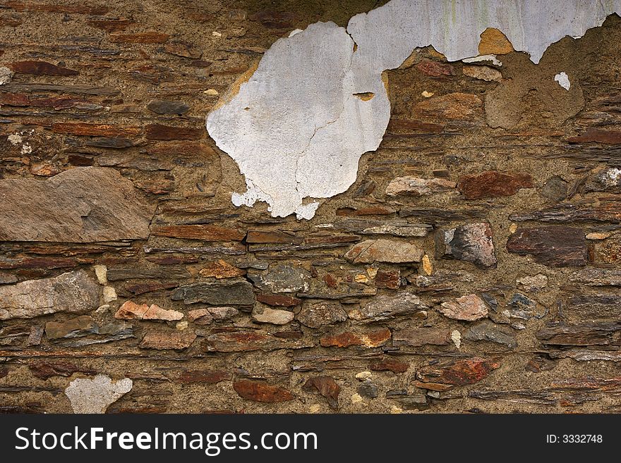 An old wall with chip of stucco. Stonework texture.