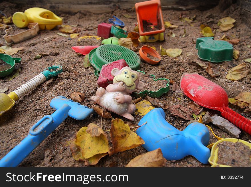 Forgotten toys in a dirty sandbox. Depressive mood. Forgotten toys in a dirty sandbox. Depressive mood.