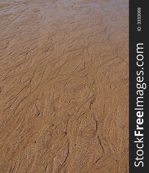 Wet sand on English beach, Cornwall, with small rivers running from the sea. Wet sand on English beach, Cornwall, with small rivers running from the sea