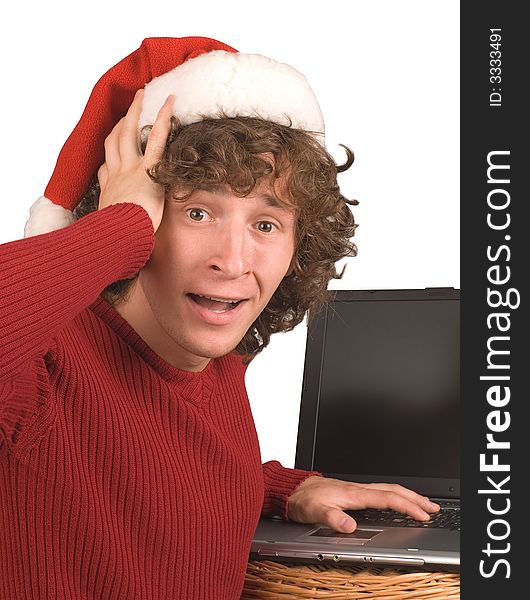 Young the man in cap Santa Claus with a computer on a white background. Young the man in cap Santa Claus with a computer on a white background