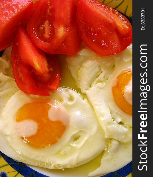 Tomatoes in a plate with fried eggs. Lunch time. Tomatoes in a plate with fried eggs. Lunch time