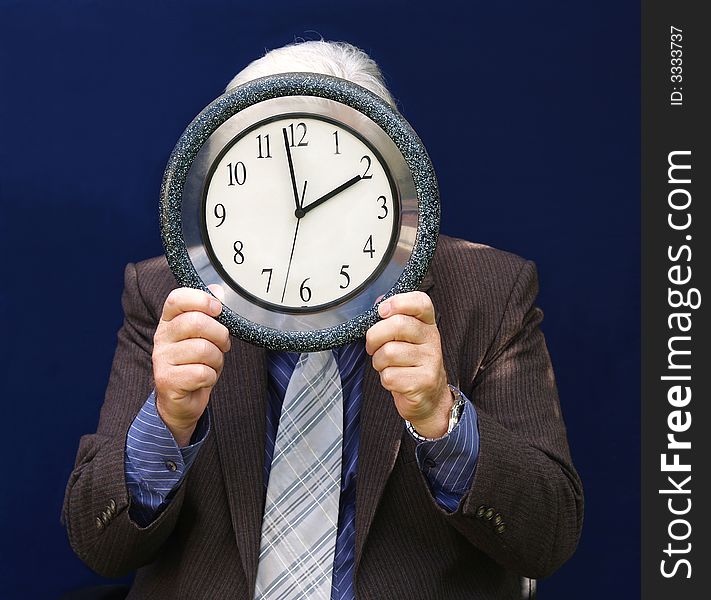 Senior executive holding a clock with end of Lunch Time