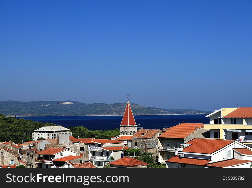 City and its church tower in front of the sea. City and its church tower in front of the sea