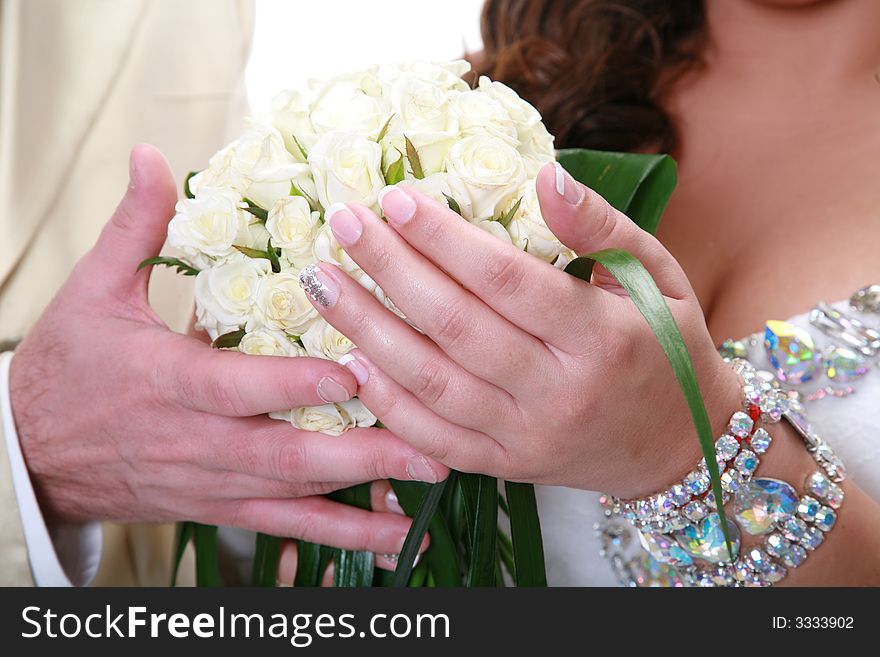 Wedding bouquet in hands at the groom and the bride