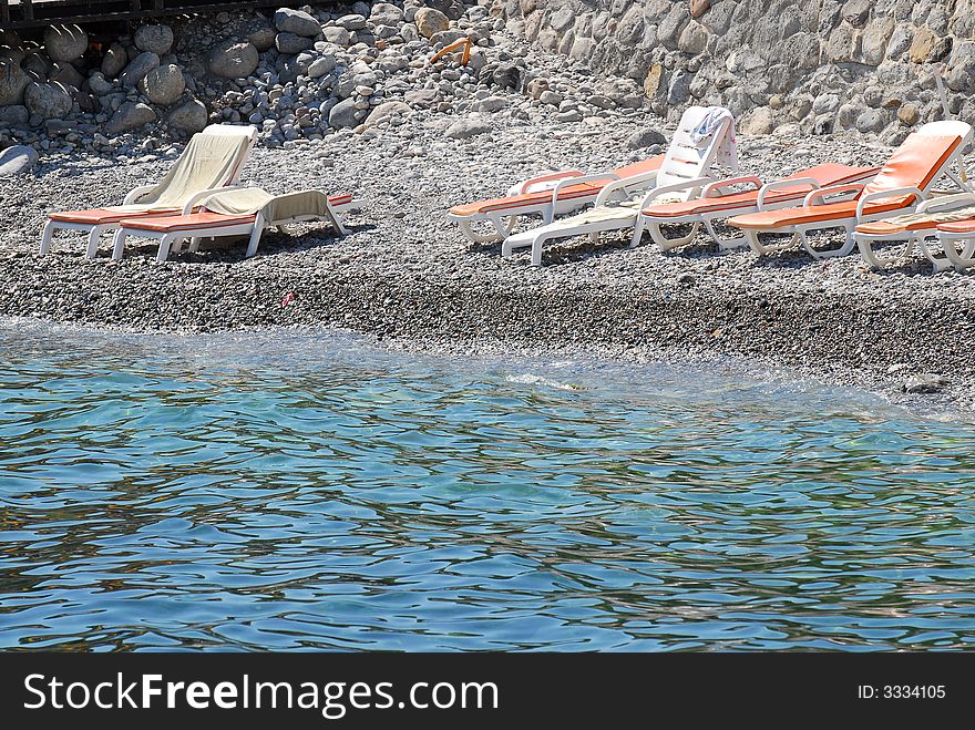 Small beach with chaise lounges on seacoast