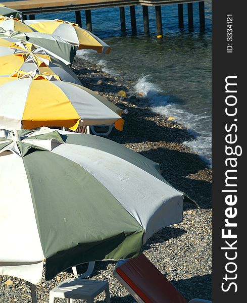 Beach umbrellas of different colors on seacoast