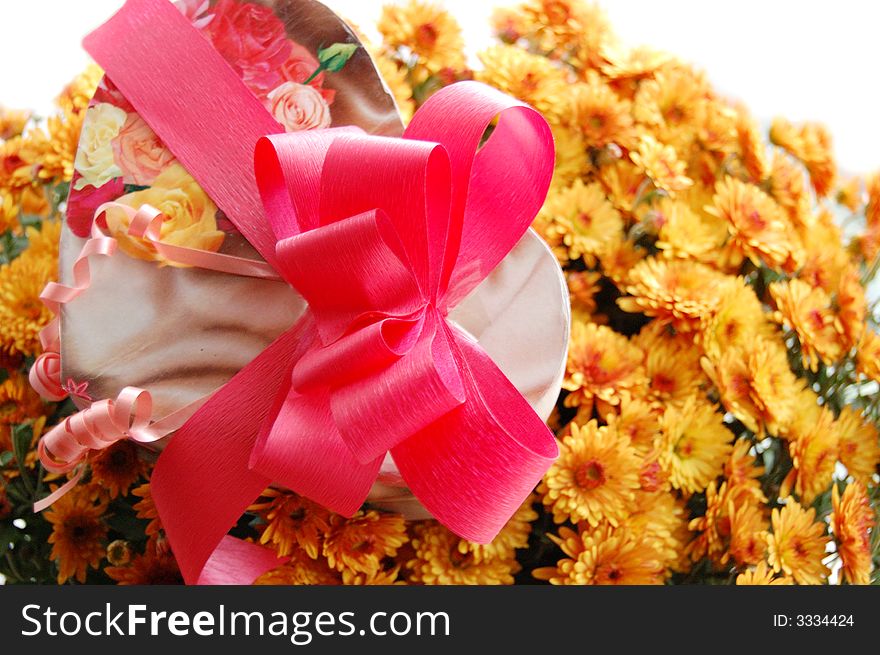 Present box with pink ribbon and bouquet of chrysanthemums. Present box with pink ribbon and bouquet of chrysanthemums