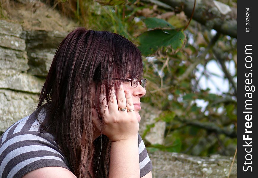 Teenage girl with a bored expression outside an abandoned building