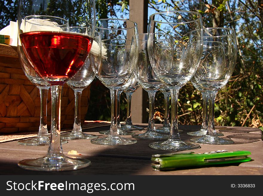 Glass of wine with empty glasses in background and bottle opener. Glass of wine with empty glasses in background and bottle opener