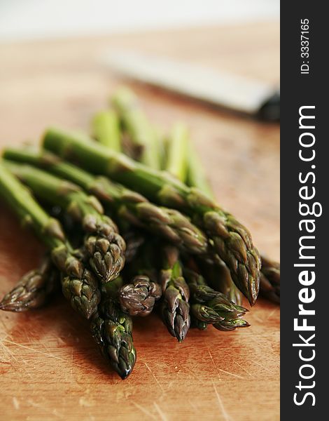 A close up of some asparagus and kitchen knife. A close up of some asparagus and kitchen knife