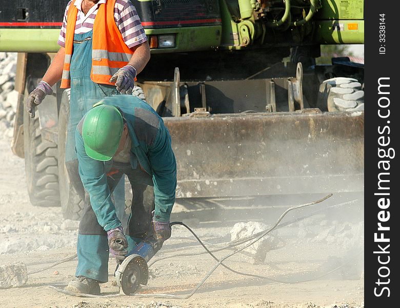 A worker using a grinder